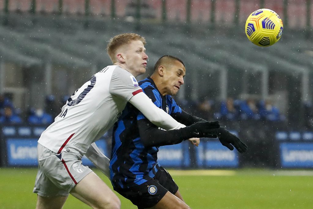 Bologna's Jerdy Schouten, left, and Inter Milan's Alexis Sanchez fight for the ball during a Serie A soccer match between Inter Milan and Bologna, at Milan's San Siro Stadium, Saturday, Dec. 5, 2020. (AP Photo/Antonio Calanni)