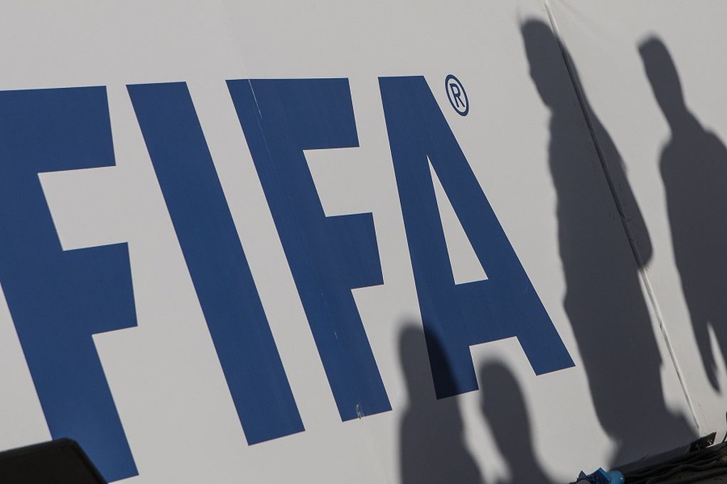 06/01/2020 FILED - 06 January 2020, Egypt, Giza: The shadows of spectators can be seen on a FIFA banner. Male players born in 1997 can play at the postponed 2020 Tokyo Olympics next year although they have officially exceeded the tournament age limit, ...