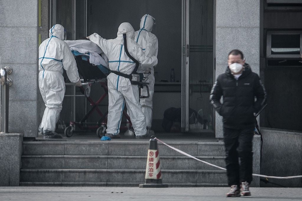 (FILES) This file photo taken on January 18, 2020 shows medical staff members carrying a patient into the Jinyintan hospital, where patients infected by a mysterious SARS-like virus are being treated, in Wuhan in China's central Hubei province. - A mysterious SARS-like virus has spread around China -- including to Beijing -- authorities said on January 20, 2020, fuelling fears of a major outbreak as millions begin travelling for the Lunar New Year in humanity's biggest migration. (Photo by STR / AFP) / China OUT