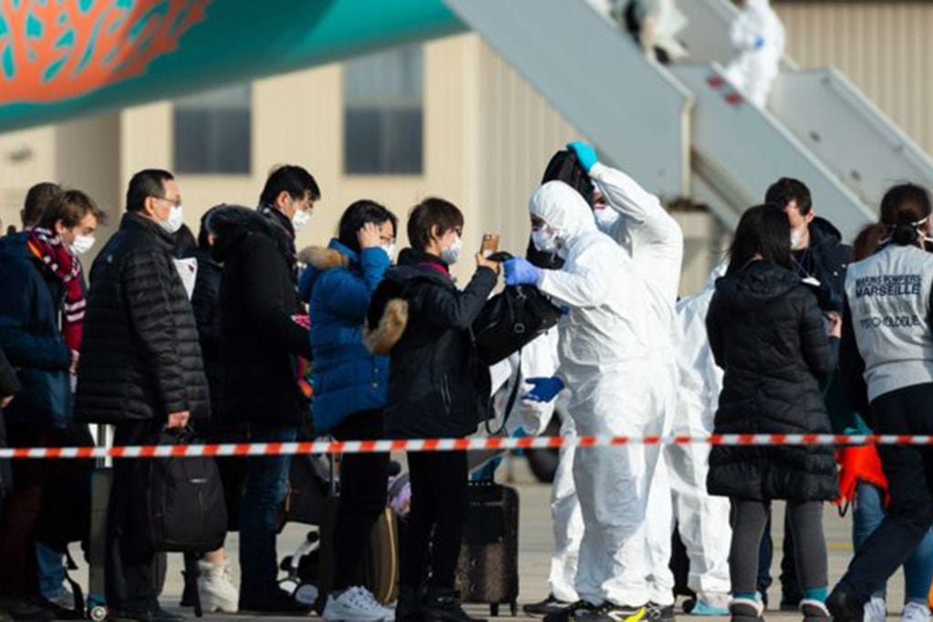 This handout photo taken and released by the French Defence Audiovisual Production and Communication Unit (ECPAD) on February 2, 2020, shows passengers being checked as they disembark from a plane carrying French citizens flown out of the coronavirus hot-zone in Wuhan, upon their arrival at the Istres-Le Tube Air Base in Istres, southeastern France. - At least 65 more French citizens began a quarantine period in southern France on February 2, after a second repatriation plane landed in Istres carrying overall 250 people from Wuhan, the epicentre of the new coronavirus infection epidemic. (Photo by Handout / ECPAD / AFP) / RESTRICTED TO EDITORIAL USE - MANDATORY CREDIT "AFP PHOTO / ECPAD / EMA" - NO MARKETING - NO ADVERTISING CAMPAIGNS - DISTRIBUTED AS A SERVICE TO CLIENTS - TO BE USED WITHIN 30 DAYS FROM 02/02/2020   --- NO ARCHIVE ---