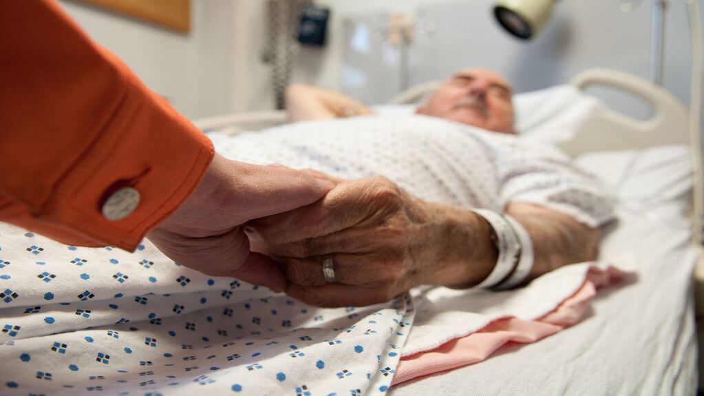 This senior citizen gets comfort from his daughter as she holds his hand before surgery (that will later reveal cancer).