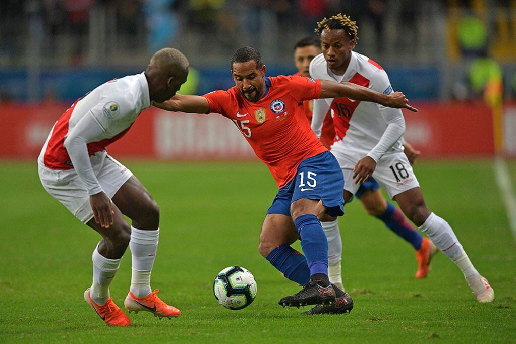Chile's Jean Beausejour (C) vies for the ball with Peru's Luis Advincula (L) and Andre Carrillo vie for the ball during their Copa America football tournament semi-final match at the Gremio Arena in Porto Alegre, Brazil, on July 3, 2019. / AFP / Carl D...
