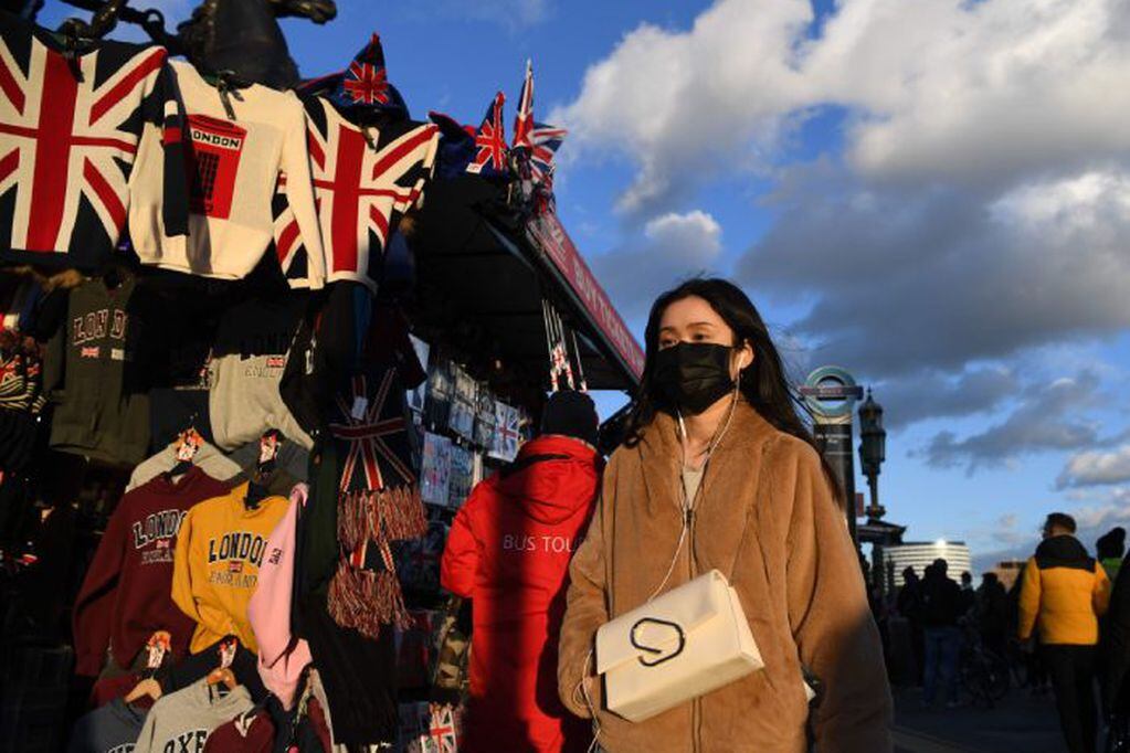 A pedestrian wears a face mask as they cross Westminster Bridge in central London on March 2, 2020. - Britain's Prime Minister Prime Minister on Monday chaired an emergency COBRA meeting on the coronavirus outbreak, as the number of confirmed cases of COVID-19 in the United Kingdom rose to 40. (Photo by DANIEL LEAL-OLIVAS / AFP)