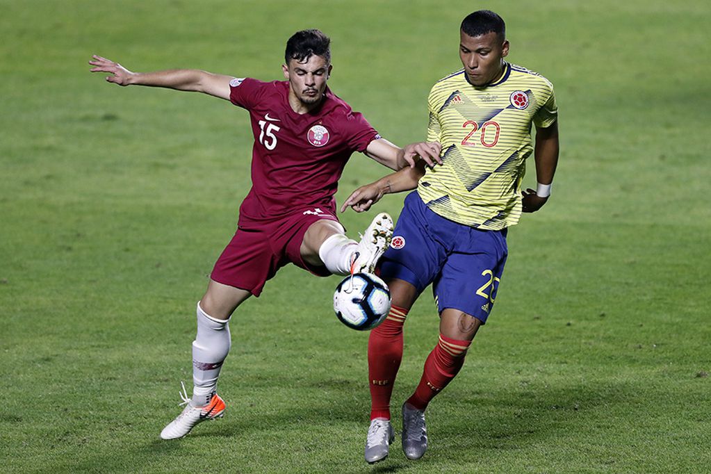 Qatar's Bassam Al Rawi, left, fights for the ball with Colombia's Roger Martinez during a Copa America Group B soccer match at Morumbi stadium in Sao Paulo, Brazil, Wednesday, June 19, 2019. (AP Photo/Nelson Antoine)