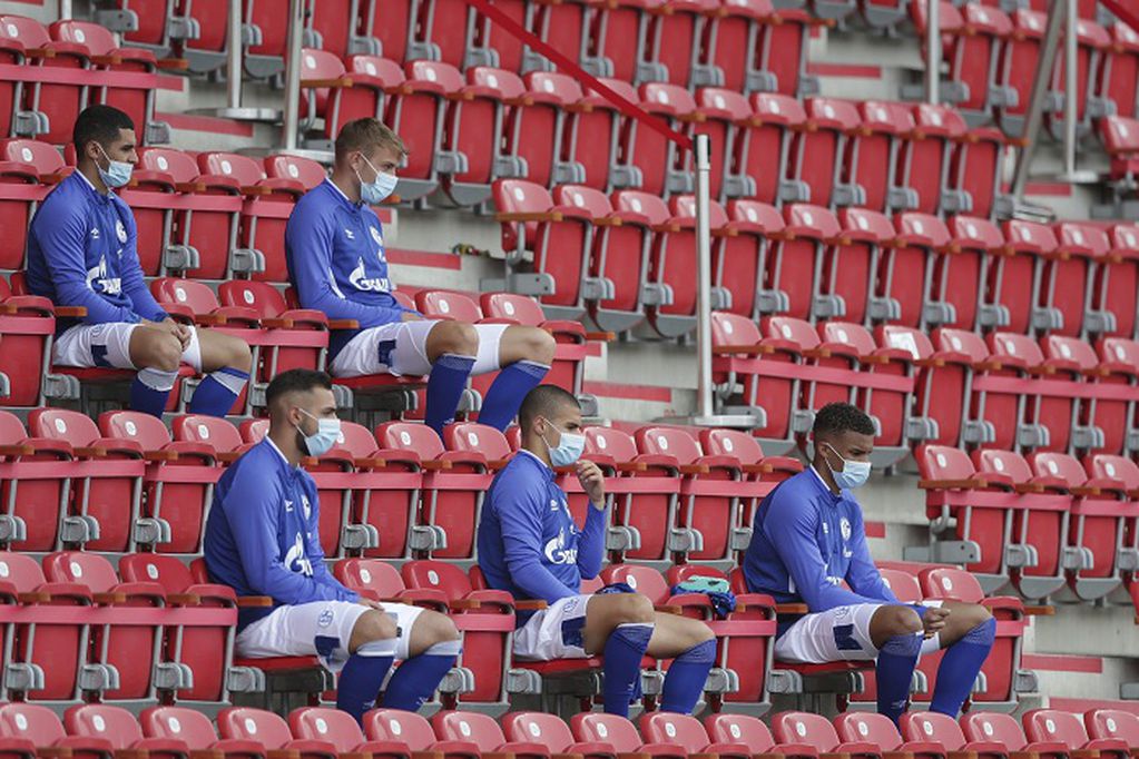Schalke alternate players sit on the bench during the German Bundesliga soccer match between 1. FC Union Berlin and FC Schalke 04 in Berlin, Germany, Sunday, June 7, 2020. The German Bundesliga is the world's first major soccer league to resume after a two-month suspension because of the coronavirus pandemic. (AP Photo/Michael Sohn, Pool)