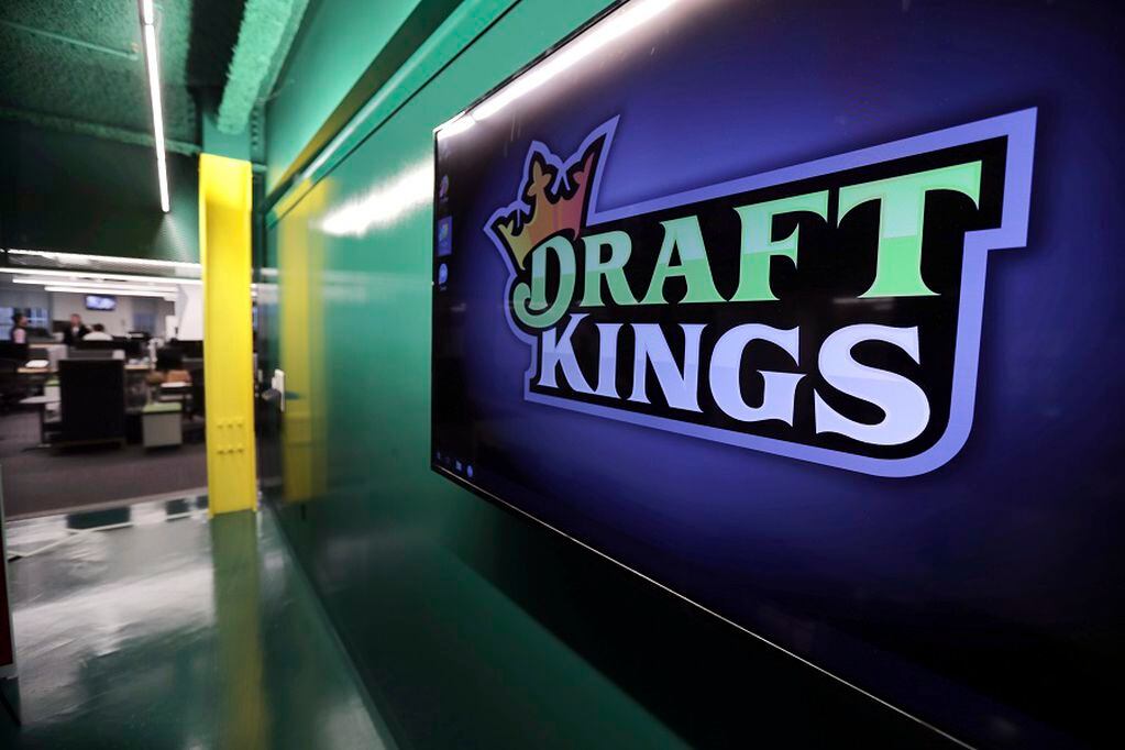 FILE - In this May 2, 2019, file photo, the DraftKings logo is displayed at the sports betting company headquarters in Boston.  DraftKings shares jumped 4% in morning trading, Wednesday, Sept. 2, 2020 after announcing that basketball legend Michael Jordan would take an ownership stake in the company in exchange for becoming a special adviser to the sports betting site.  (AP Photo/Charles Krupa, File)