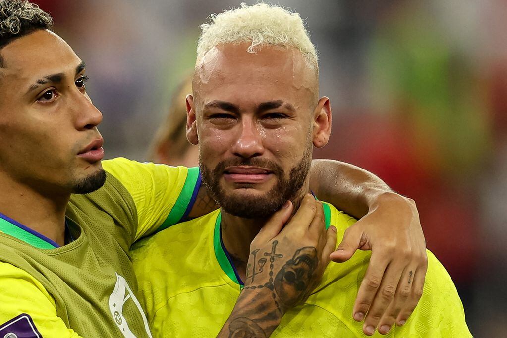 TOPSHOT - Brazil's forward #10 Neymar (R) is consoled by Brazil's forward #11 Raphinha after their team lost the Qatar 2022 World Cup quarter-final football match between Croatia and Brazil at Education City Stadium in Al-Rayyan, west of Doha, on December 9, 2022. (Photo by Adrian DENNIS / AFP)