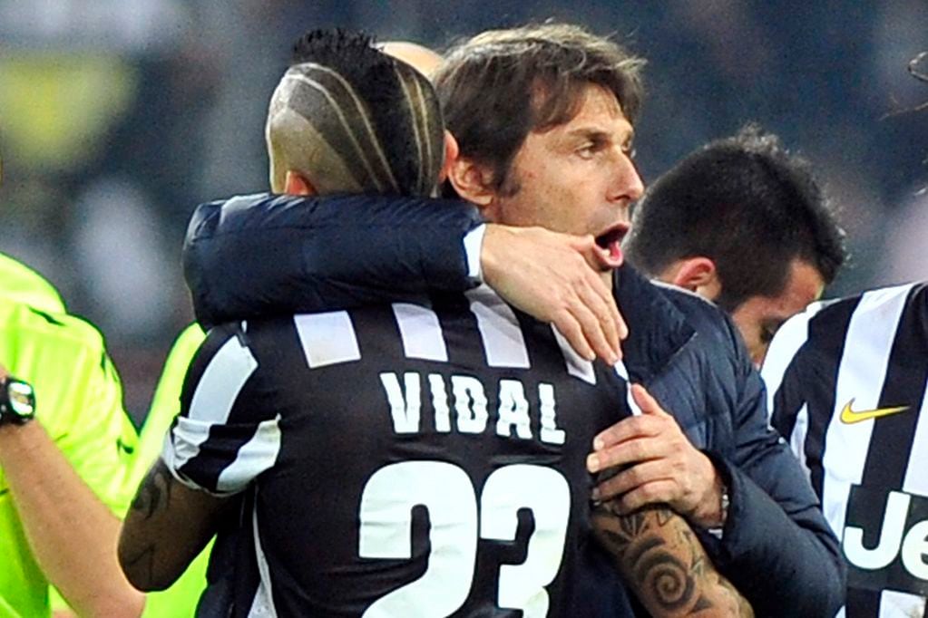 FILE - In this Feb. 2, 2014 file photo, then Juventus coach Antonio Conte, celebrates with Arturo Vidal after a Serie A soccer match between Juventus and Inter Milan at the Juventus stadium, in Turin, Italy. Former Juventus midfielder Arturo Vidal has joined Inter Milan, where he will be reunited with coach Antonio Conte. (AP Photo/Massimo Pinca)