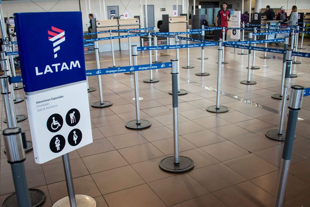 (FILES) In this file photo taken on April 10, 2018 Lan Express' check-in area at the departures terminal of Santiago's international airport remains empty, during an indefinite strike called by cabin crew workers of the company. - Latin America's biggest airline, the Brazilian-Chilean group LATAM, filed for bankruptcy in the US, according to a statement on May 25, 2020. (Photo by Martin BERNETTI / AFP)