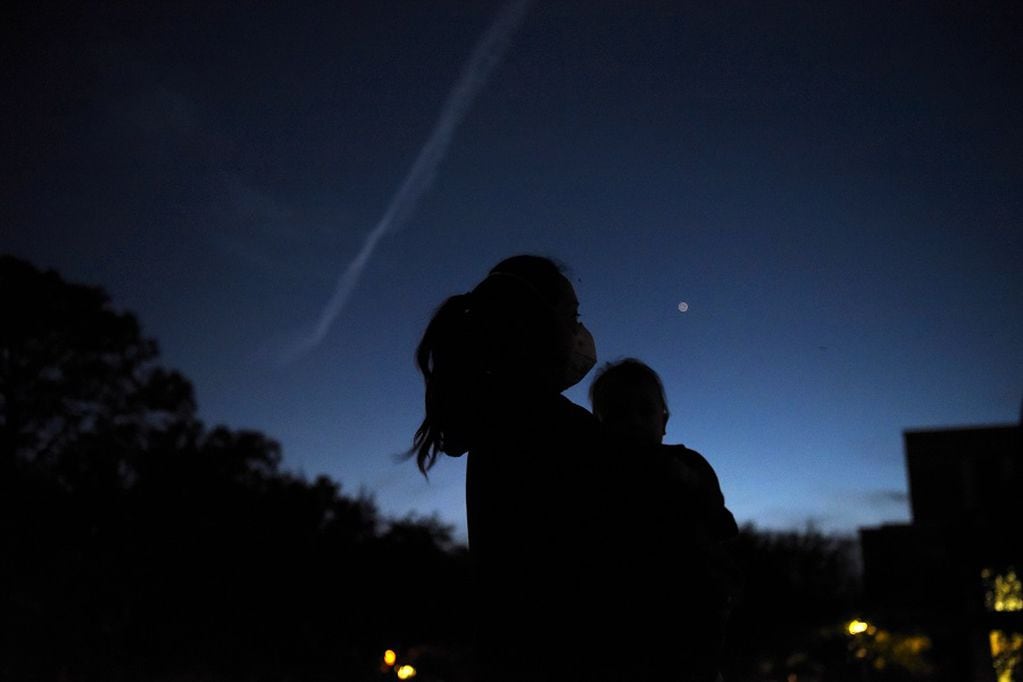 Thao Galvan holds her son Nathan while they view Jupiter and Saturn during a planetary conjuction, as they appear close together in a rare celestial event in Houston, Texas, U.S., December 21, 2020. REUTERS/Callaghan O'Hare