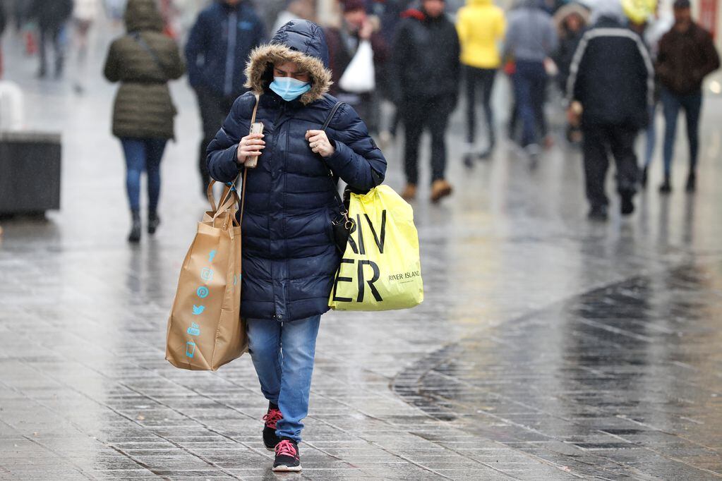 A woman wearing a face mask carries shopping bags amid the outbreak of the coronavirus disease (COVID-19) in Liverpool, Britain, October 12, 2020. REUTERS/Phil Noble