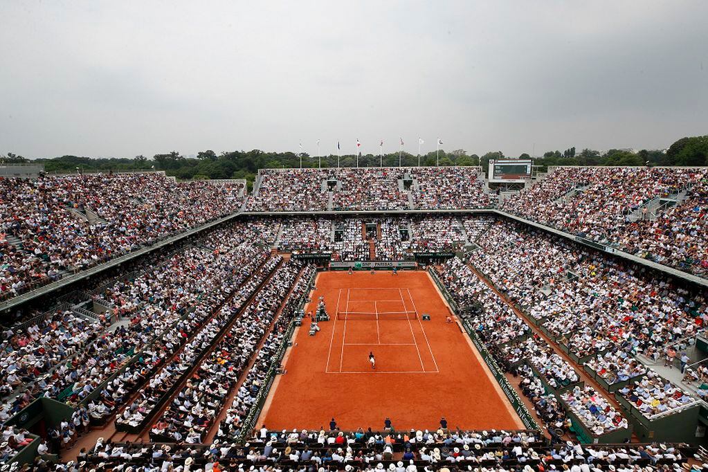 FILE - In this June 10, 2018 file photo, the crowd watch Austria's Dominic Thiem serving to Spain's Rafael Nadal during the men's final match of the French Open tennis tournament at the Roland Garros stadium,in Paris. The French Tennis Federation says up to 60% of the stands can be filled with fans when play starts in September at Roland Garros. The clay-court tournament had been scheduled to start on May 24 but was postponed to Sept. 20 because of the coronavirus pandemic. (AP Photo/Christophe Ena, File)