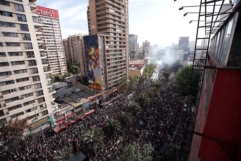 AME7600. SANTIAGO (CHILE), 29/10/2019. -Manifestantes protestan en las calles cercanas a la céntrica Plaza Italia, durante la décima jornada consecutiva de protestas a nivel nacional en contra del Gobierno, este martes en Santiago (Chile). EFE/Alberto Valdes