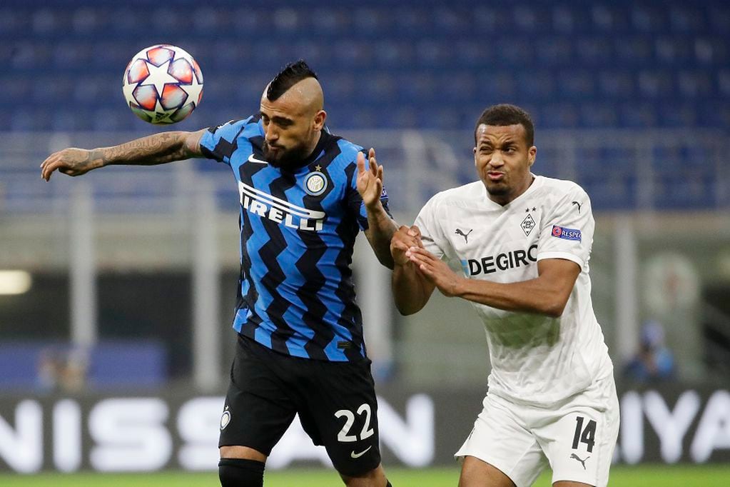 Inter Milan's Arturo Vidal, left, challenges for the ball with Moenchengladbach's Alassane Plea during the Champions League group B soccer match between Inter Milan and Borussia Moenchangladbach at the San Siro stadium in Milan, Italy, Wednesday, Oct. 21, 2020. (AP Photo/Luca Bruno)