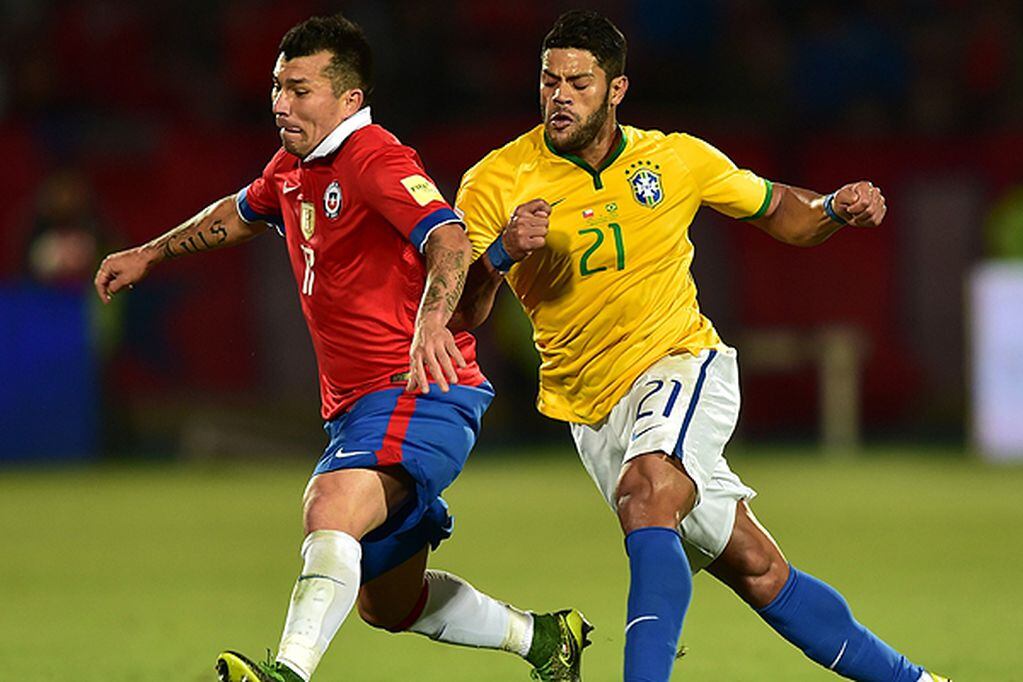 Chile's Gary Medel (L) and Brazil's Hulk vie for the ball during their Russia 2018 FIFA World Cup qualifiers match, at the Nacional stadium in Santiago de Chile, on October 8, 2015.   AFP PHOTO / MARTIN BERNETTI
