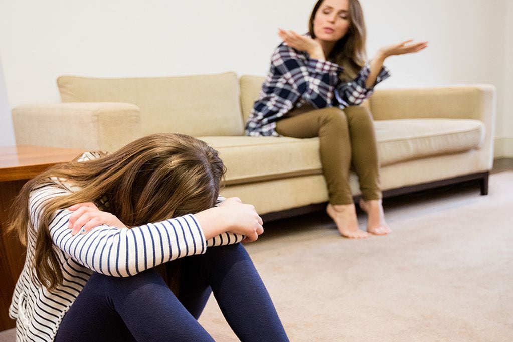 Mother shouting at her daughter in living room at home