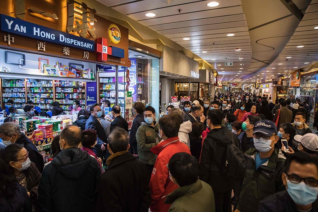 People wait in a queue and gather outside outside a pharmacy selling masks in Hong Kong on January 30, 2020, as a preventative measure after a virus outbreak which began in the Chinese city of Wuhan. - Long queues outside of pharmacies and panic buying at supermarkets has become commonplace in Hong Kong in recent days as the crowded metropolis panics over the spread of China's new coronavirus. (Photo by DALE DE LA REY / AFP)