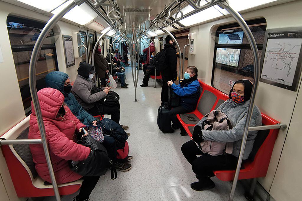 15 de Junio del 2020/SANTIAGO 
Pese a llevar 100 días de cuarentena la comuna de Santiago, aun es posible ver gran cantidad de personas usando el metro en la mañana para llegar a sus lugares de trabajo. En la imagen personas sentadas en un vagón 
FOTO: FRANCISCO CASTILLO /AGENCIAUNO