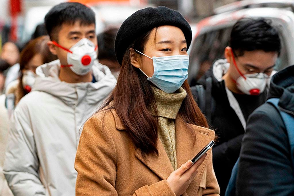 Pedestrians are seen wearing a surgical masks in London's China Town on January 25, 2020. - European airports from London to Moscow stepped up checks Wednesday on flights from the Chinese city at the heart of a new SARS-like virus that has killed 41 people and spread to the United States. Britain advised against "all but essential travel" to Wuhan -- the central China city from where the virus spread -- while European health authorities put the threat of the virus spreading to "moderate". The coronavirus has sparked alarm because of its similarity to the outbreak of SARS (Severe Acute Respiratory Syndrome) that killed nearly 650 people across mainland China and Hong Kong in 2002-03. The new virus emerged on the eve of the Lunar New Year holiday during which hundreds of million travel across China to meet up with their families. (Photo by Niklas HALLE'N / AFP)