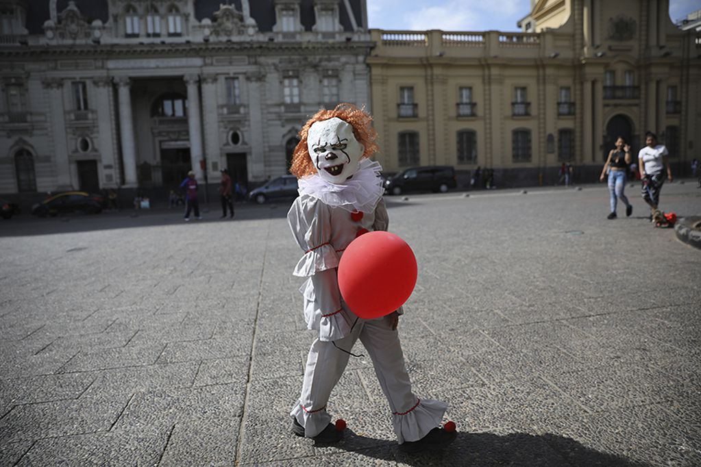A child walks in an evil clown Halloween costume in Santiago, Chile, Thursday, Oct. 31, 2019. Chile has been facing days of unrest, triggered by a relatively minor increase in subway fares. The protests have shaken a nation noted for economic stability over the past decades, which has seen steadily declining poverty despite persistent high rates of inequality. (AP Photo/Rodrigo Abd)