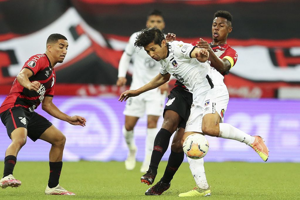 Matias Fernandez of Chile's Colo Colo, front, fights for the ball with Wellington of Brazil's Athletico Paranaense during a Copa Libertadores soccer match at the Arena da Baixada stadium in Curitiba, Brazil, Wednesday, Sept. 23, 2020. (Heuler Andrey, Pool via AP)