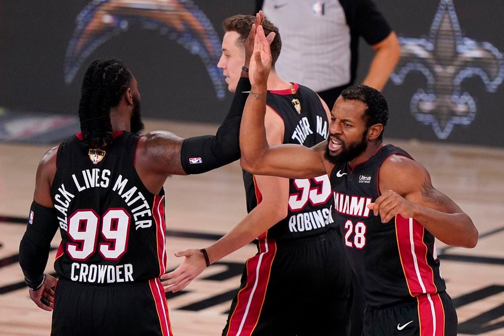 Miami Heat forward Jae Crowder, left, guard Duncan Robinson and guard Andre Iguodala celebrates during the first half in Game 4 of basketball's NBA Finals against the Los Angeles Lakers Tuesday, Oct. 6, 2020, in Lake Buena Vista, Fla. (AP Photo/Mark J. Terrill)