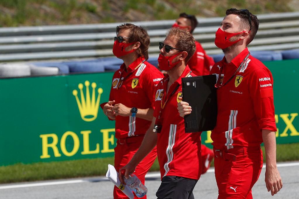 Ferrari driver Sebastian Vettel, center, inspects the track with his team at the Red Bull Ring racetrack in Spielberg, Austria, Thursday, July 2, 2020. Austrian Formula One Grand Prix will be held on Sunday. (AP Photo/Darko Bandic)
