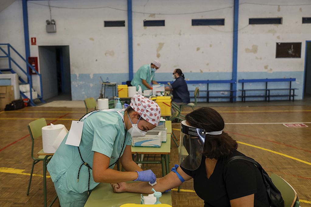 Teachers and auxiliary staff take COVID-19 tests in Madrid, Spain, Thursday, Sept. 3, 2020. The Madrid region is a coronavirus hot spot, with almost 32,000 new cases officially recorded over the past two weeks. The tests are mandatory for school employees. (AP Photo/Bernat Armangue)