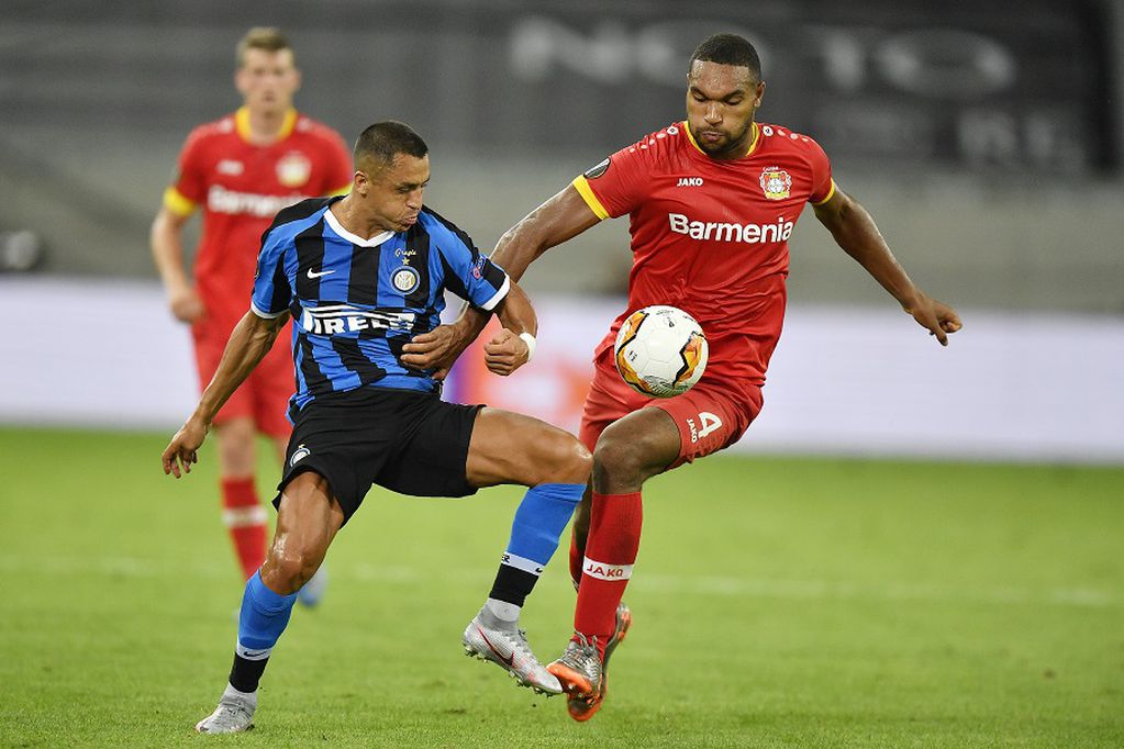 Inter Milan's Alexis Sanchez, left, challenges for the ball with Leverkusen's Jonathan Tah during the Europa League quarter finals soccer match between Inter Milan and Bayer Leverkusen at Duesseldorf Arena, in Duesseldorf, Germany, Monday, Aug. 10, 2020. (AP Photo/Martin Meissner)