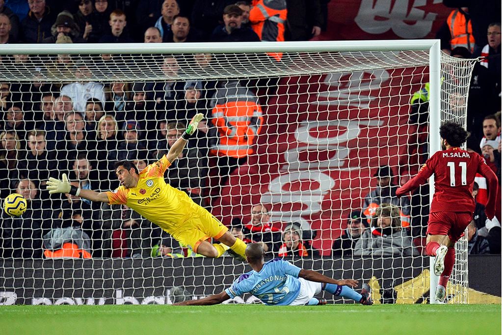 Liverpool (United Kingdom), 10/11/2019.- Mohamed Salah (R) of Liverpool scores the 2-0 lead past Manchester City's goalkeeper Claudio Bravo (L) during the English Premier League soccer match between Liverpool FC and Manchester City in Liverpool, Britain, 10 November 2019. (Reino Unido) EFE/EPA/PETER POWELL EDITORIAL USE ONLY. No use with unauthorized audio, video, data, fixture lists, club/league logos or 'live' services. Online in-match use limited to 120 images, no video emulation. No use in betting, games or single club/league/player publications