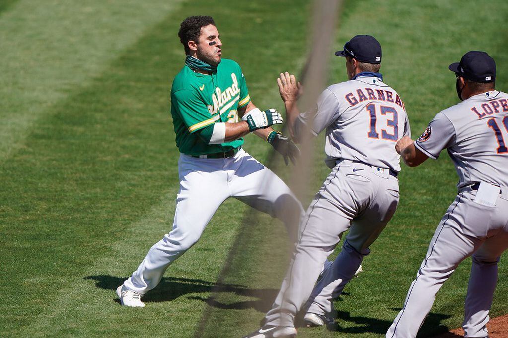 Aug 9, 2020; Oakland, California, USA;  Houston Astros catcher Dustin Garneau (13) attempts to stop Oakland Athletics right fielder Ramon Laureano (22) during the seventh inning at the Oakland Coliseum. Mandatory Credit: Stan Szeto-USA TODAY Sports