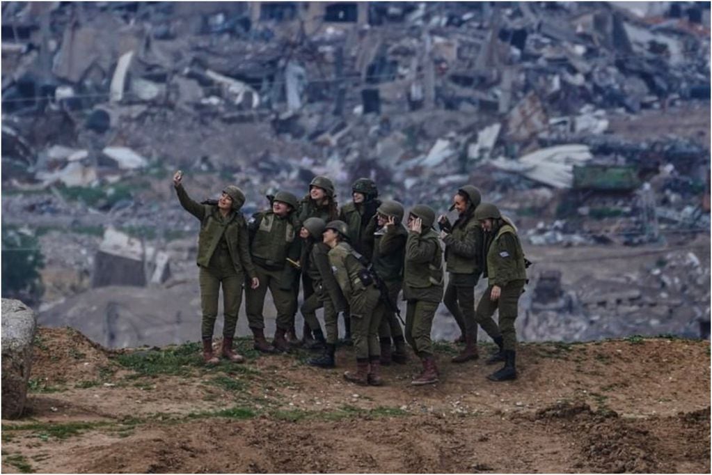 Soldados israelí tomándose selfie con ruinas de Gaza de fondo. Foto por Tsafrir Abayov.