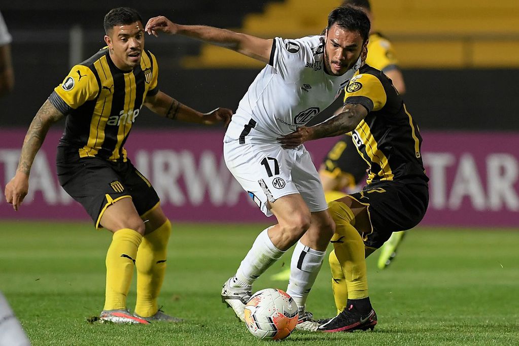 Uruguay's Penarol midfielder David Terans (L) and Uruguay's Penarol midfielder Jesus Trindade (R) vie for the ball with Chile's Colo Colo midfielder Gabriel Suazo (C) during their closed-door Copa Libertadores group phase football match at the Campeon del Siglo Stadium in Banados de Carrasco, Montevideo Department, Uruguay, on September 29, 2020, amid the COVID-19 novel coronavirus pandemic. (Photo by Sandro Pereyra / POOL / AFP)