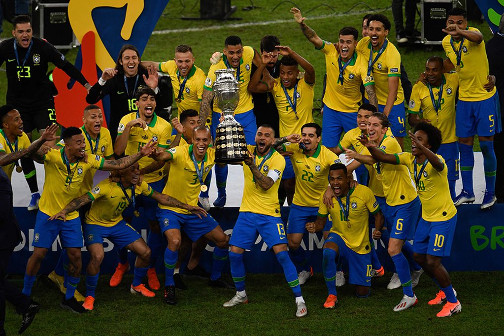 Brazil's Dani Alves (C) and teammates celebrates with the trophy after winning the Copa America after defeating Peru in the final match of the football tournament at Maracana Stadium in Rio de Janeiro, Brazil, on July 7, 2019. / AFP / MAURO PIMENTEL
