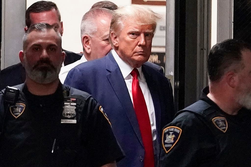 FILE - Former President Donald Trump is escorted to a courtroom, April 4, 2023, in New York. Federal Judge Lewis A. Kaplan issued an order Monday, April 10, 2023, directing parties to notify him if Trump plans to attend a New York trial later this month resulting from a columnist's claims that he raped her in a department store dressing room in the 1990s. (AP Photo/Mary Altaffer, File)