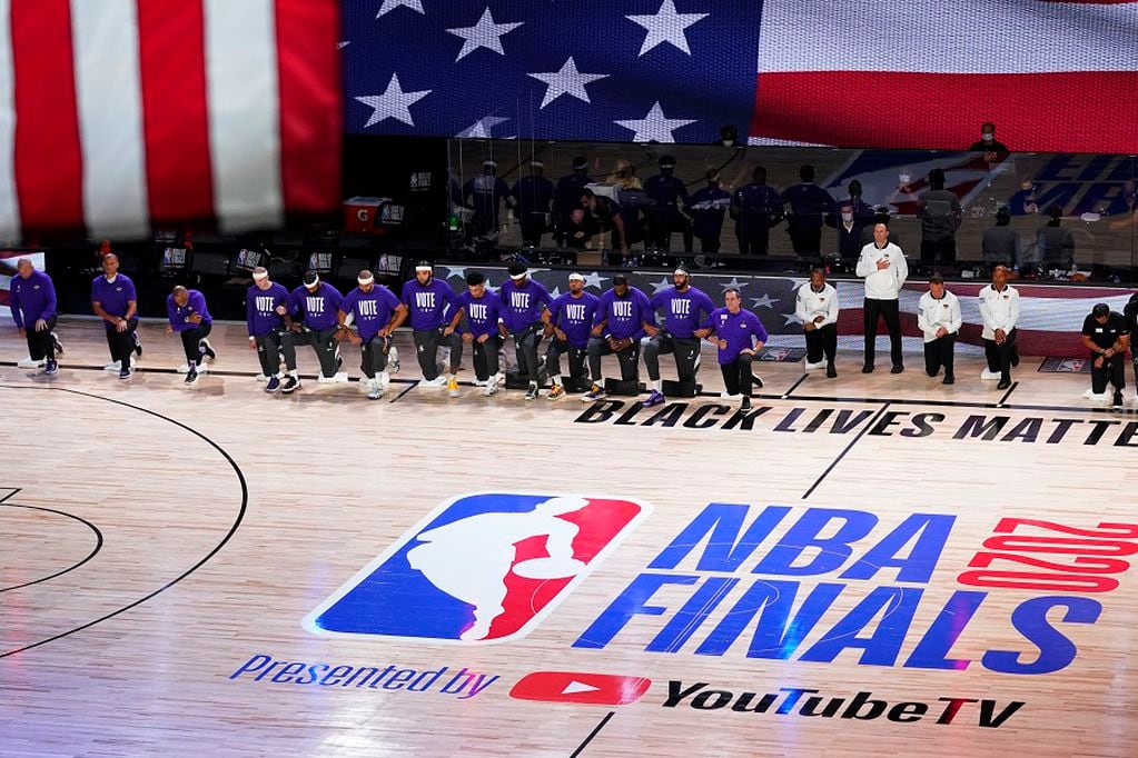 The Los Angeles Lakers kneel for the national anthem prior to the first half of Game 1 of basketball's NBA Finals Wednesday, Sept. 30, 2020, in Lake Buena Vista, Fla. (AP Photo/Mark J. Terrill)