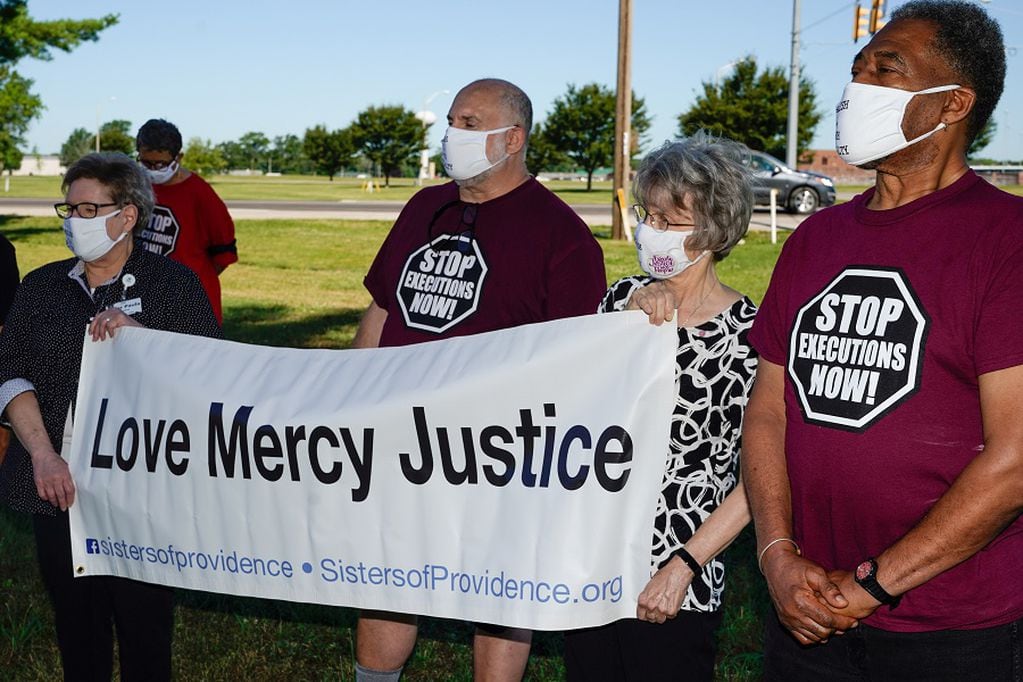 Individuals who oppose the death penalty gather outside the Federal Correctional Complex, Terre Haute, as a federal judge has momentarily prevented the execution Daniel Lewis Lee, who is convicted in the killing of three members of an Arkansas family in 1996, and would be the first federal execution in 17 years, in Terre Haute, Indiana, U.S. July 13, 2020. REUTERS/Bryan Woolston
