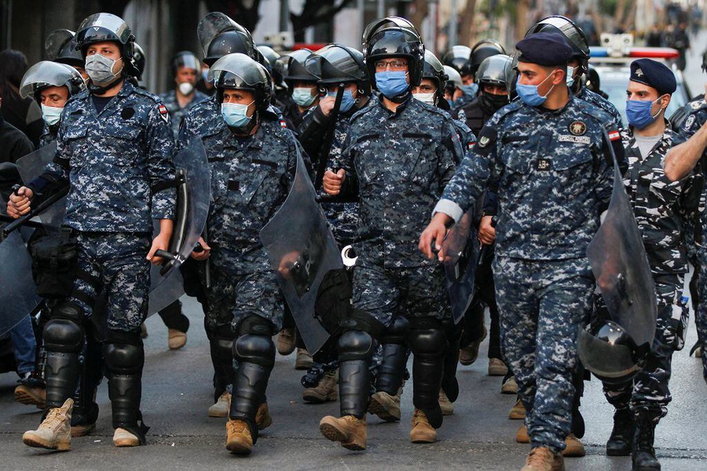 Lebanese police wear face masks as they walk together, during a protest against the collapsing Lebanese pound currency near Lebanon's Central Bank in Beirut, Lebanon April 23, 2020. REUTERS/Mohamed Azakir