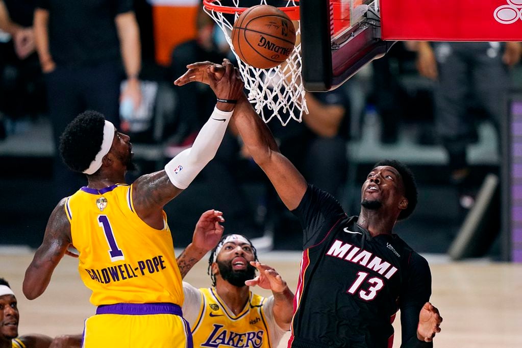 Los Angeles Lakers' Kentavious Caldwell-Pope (1) and Miami Heat's Bam Adebayo (13) battle for a rebound during the first half of Game 1 of basketball's NBA Finals Wednesday, Sept. 30, 2020, in Lake Buena Vista, Fla. (AP Photo/Mark J. Terrill)