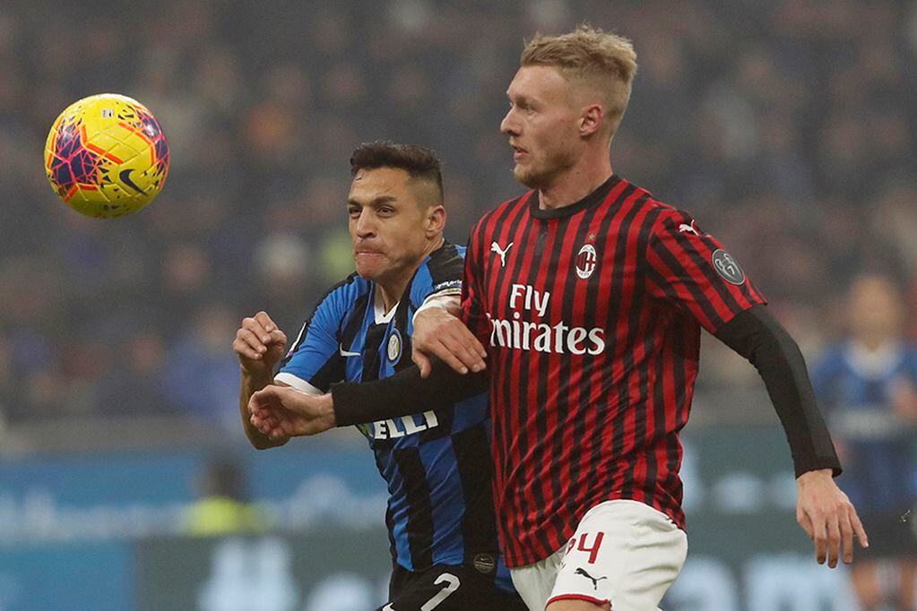 Inter Milan's Alexis Sanchez, left, vies for the ball with AC Milan's Simon Kjaer during the Serie A soccer match between Inter Milan and AC Milan at the San Siro Stadium, in Milan, Italy, Sunday, Feb. 9, 2020. (AP Photo/Antonio Calanni)