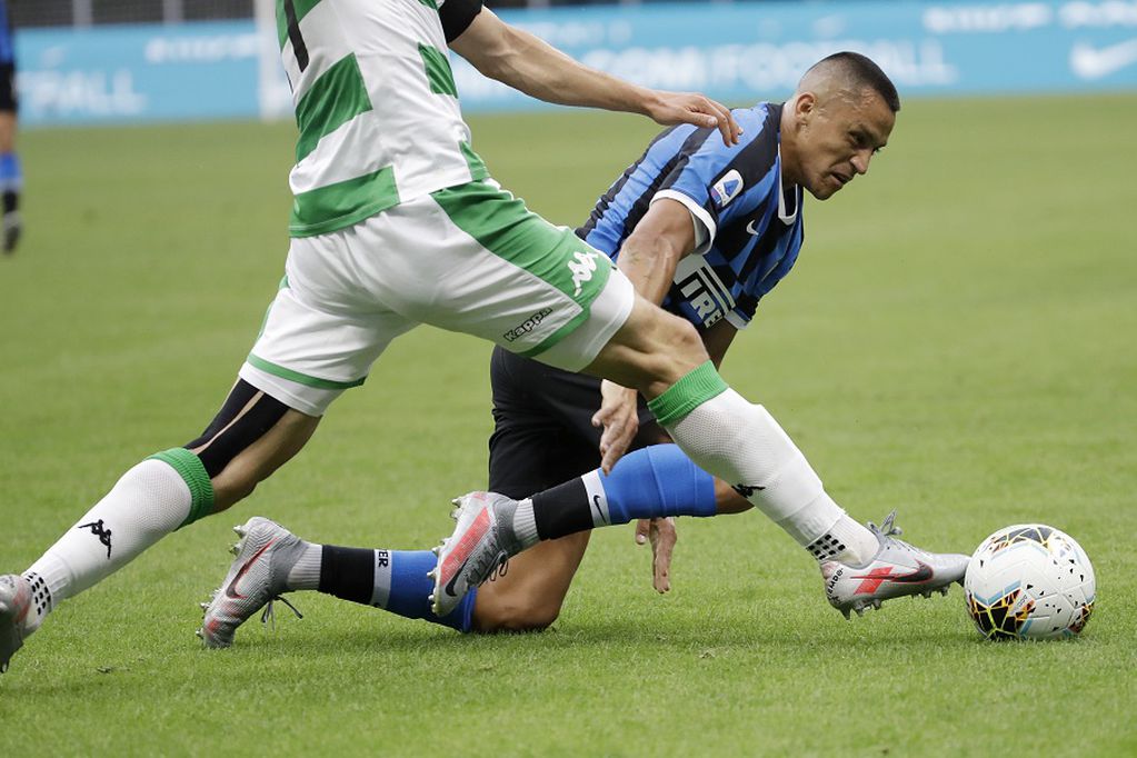 Inter Milan's Alexis Sanchez, right, challenges for the ball with Sassuolo's Marlon during the Serie A soccer match between Inter Milan and Sassuolo at the San Siro Stadium, in Milan, Italy, Wednesday, June 24, 2020. (AP Photo/Luca Bruno)