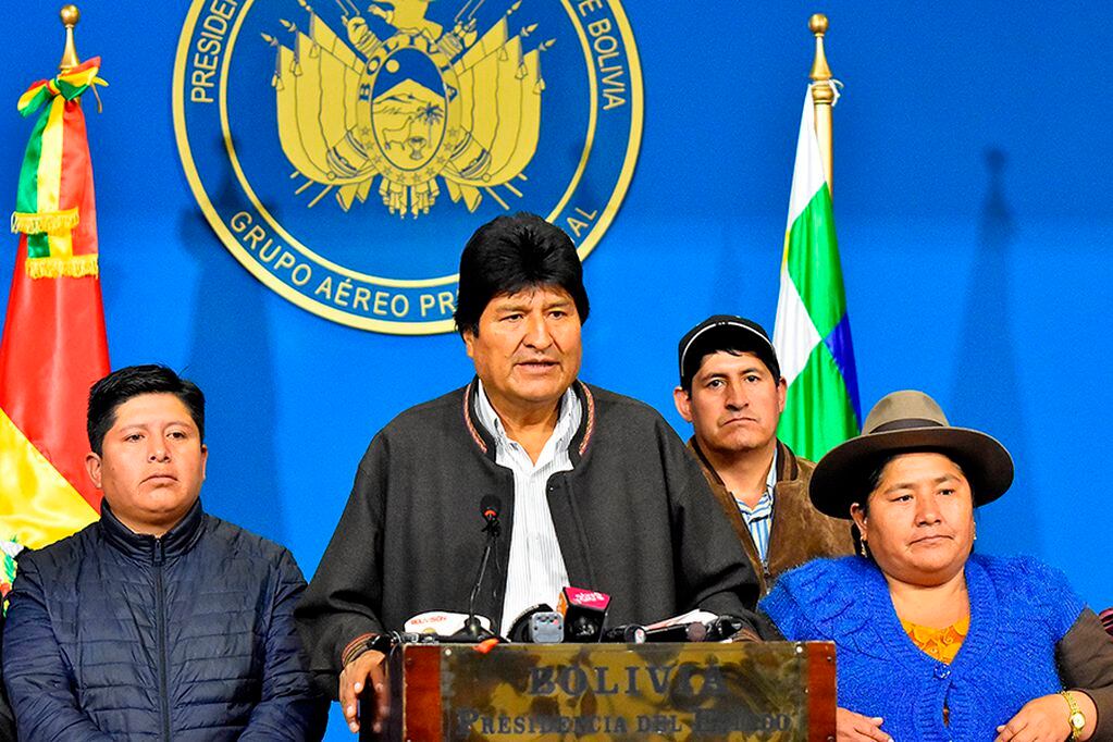 BOL47. EL ALTO (BOLIVIA), 10/11/2019.- El presidente de Bolivia, Evo Morales (2-i), habla durante una breve comparecencia este domingo en el hangar presidencial de El Alto (Bolivia). Morales anunció la convocatoria de nuevas elecciones generales, tras el informe de la Organización de Estados Americanos (OEA) que recomienda la repetición de la primera ronda de los comicios celebrados el pasado 20 de octubre que le dieron como ganador. También aseguró que la nueva cita con las urnas se celebrará con un órgano electoral renovado, ante las denuncias de fraude en la primera vuelta de las que se acusa al actual. EFE/Stringer