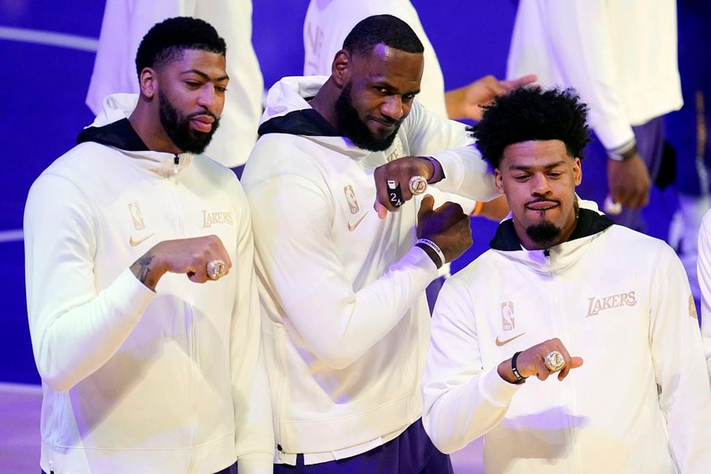 Los Angeles Lakers' Anthony Davis, left, LeBron James, center, and Quinn Cook show their championship rings before the team's NBA basketball game against the Los Angeles Clippers on Tuesday, Dec. 22, 2020, in Los Angeles. (AP Photo/Marcio Jose Sanchez)