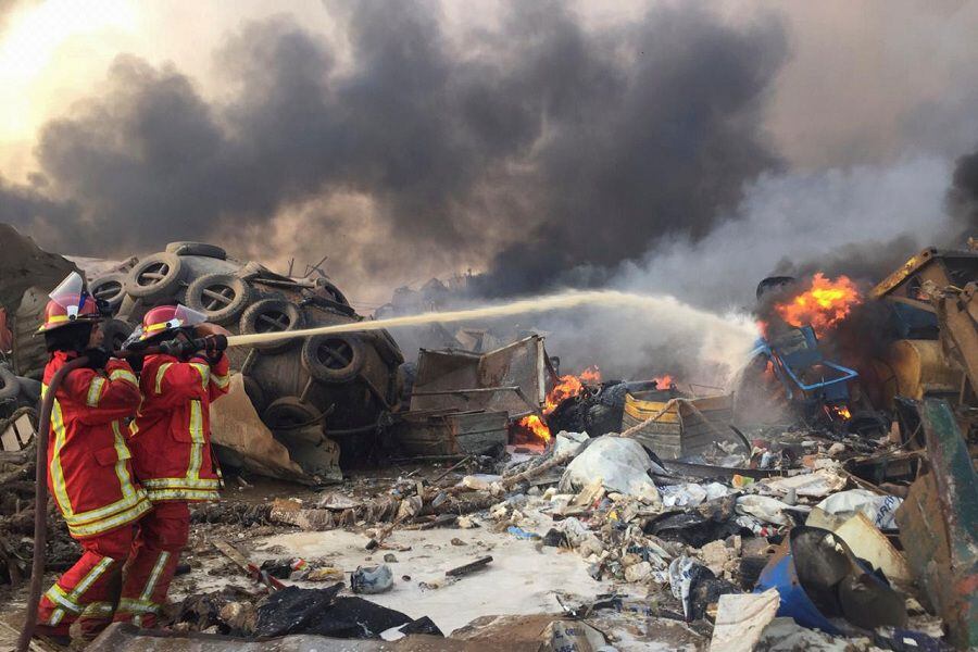 Firefighters spray water at a fire after an explosion was heard in Beirut